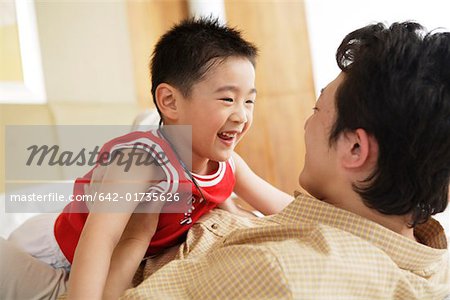 Father playing with son, smiling