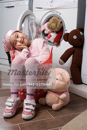 Girl sitting on basket near doll