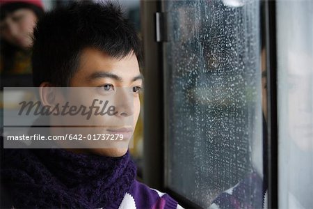 Free Stock Photo of Young Man sitting near window