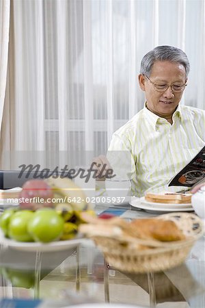 a reading old man taking breakfast