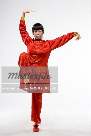 a woman in red dress practicing Chinese Kungfu