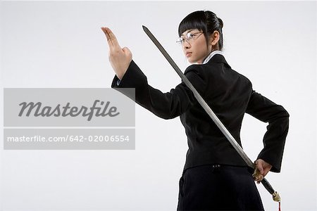 a business woman practicing Chinese Kungfu with a sword