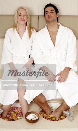 A young couple enjoying a foot bath with rose petals