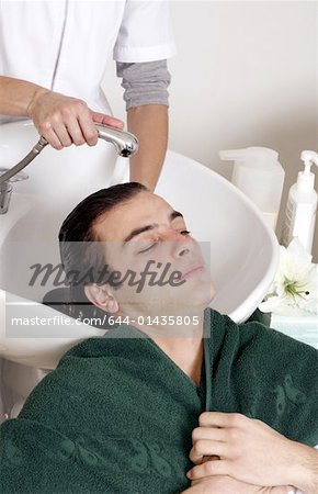 Young man having his hair  washed at a salon