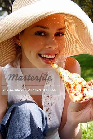 Young woman eating pizza