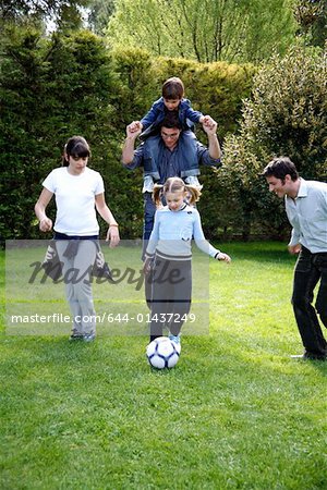 Man and children playing soccer