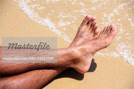 Man's bare feet on sand - Stock Photo - Masterfile - Premium