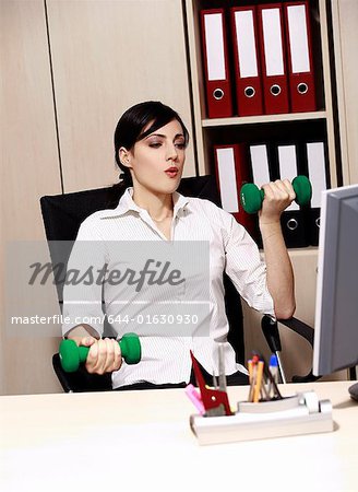Office worker at desk weight lifting