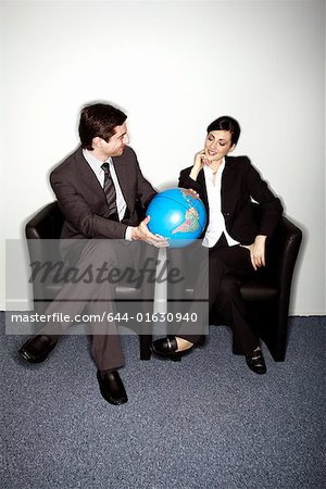 Male and female businesspeople with globe