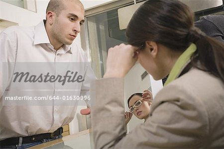 Woman trying on glasses in store
