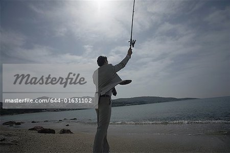 Businessman on beach fishing