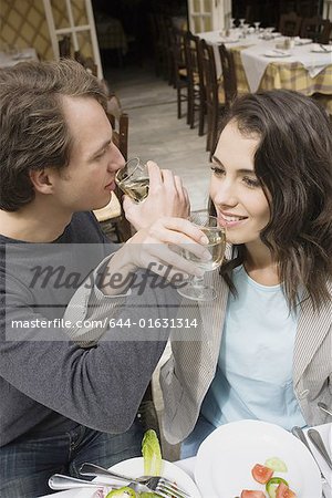 Couple drinking wine with linked arms