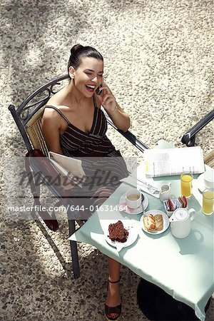 Businesswoman having breakfast in garden cafe