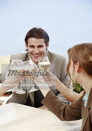 Office workers toasting with beer in outdoor cafe