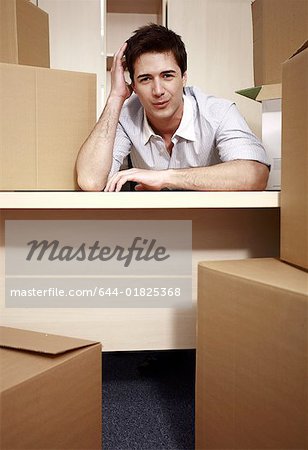 Businessman at desk among boxes