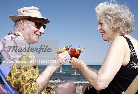 Senior couple with cocktails on beach