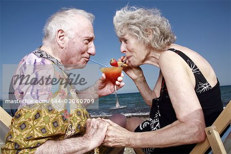 Senior couple with cocktail on beach