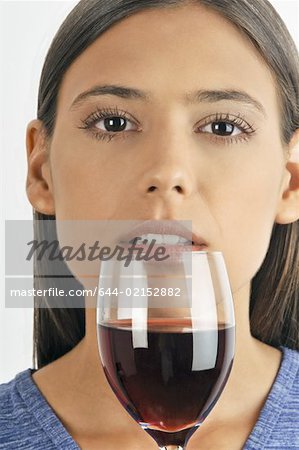 Female young adult smelling a glass of red wine