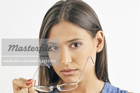 Female young adult removing eyeglasses