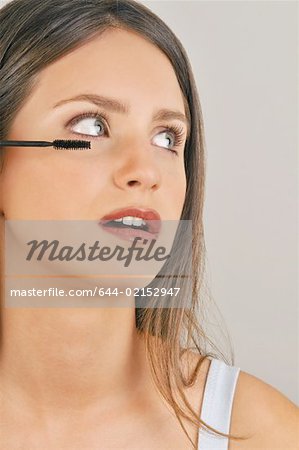 Female young adult applying mascara