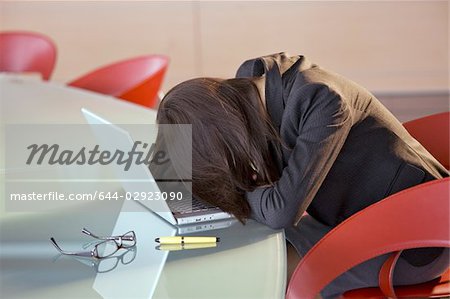 Businesswoman with head down on conference table