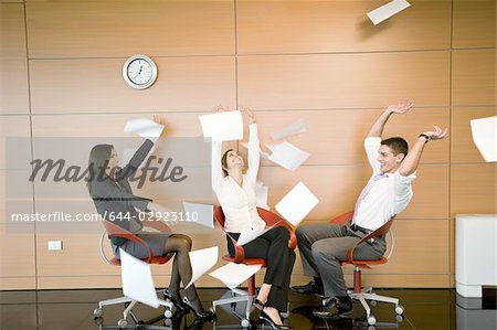 Office workers throwing documents up in the air
