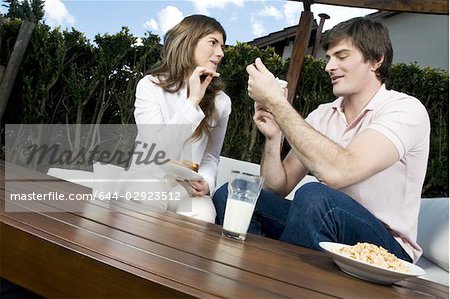 Young couple having breakfast outdoors