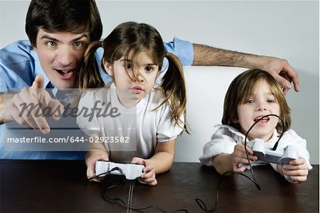Young man with children playing video game