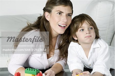 Young woman and boy playing with building blocks