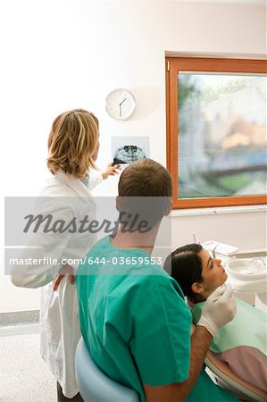 Patient with dental professionals looking at dental panoramic xray