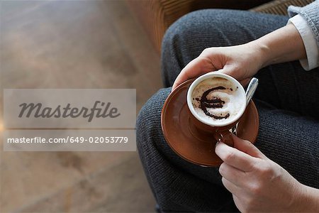Woman holding cappuccino with euro motif