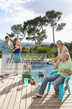Family on a wooden terrace by a pool