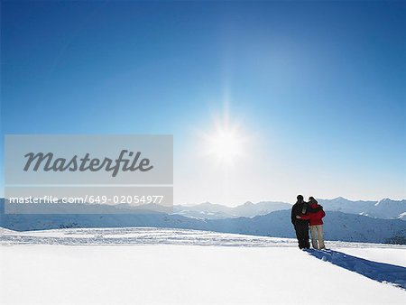 Couple walking in snow on mountain top