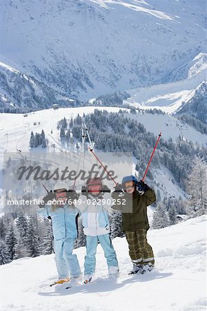 Group of kids standing in snow with skis