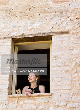 Woman and a cat looking out a window