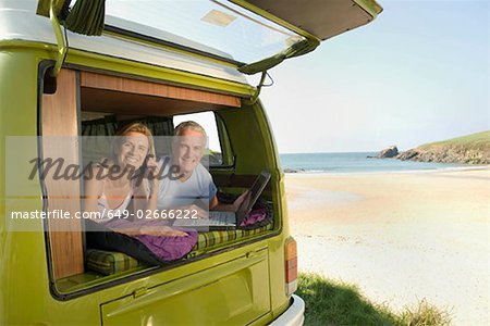 Mature couple lying in camper van