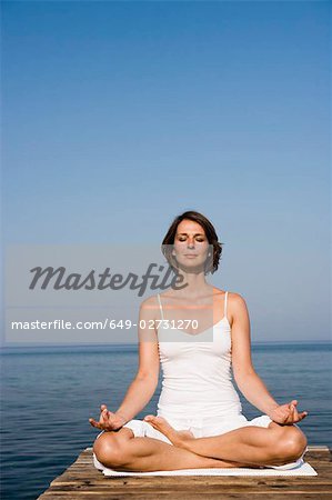 Woman doing yoga on a pier