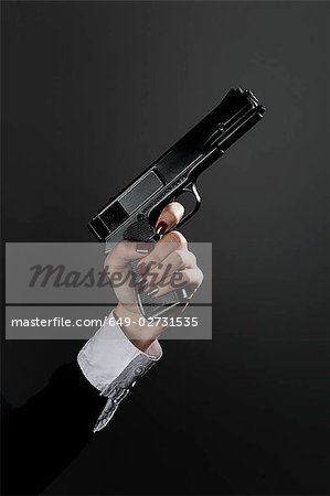 Female holding gun pose Stock Photos - Page 1 : Masterfile