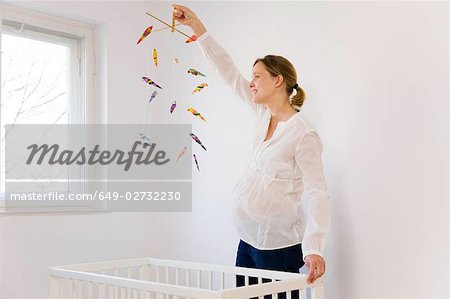 Pregnant woman looking at mobile toy