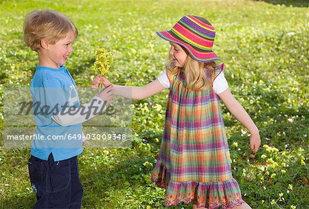 girl giving spring flower bouquet to boy
