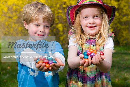 girl and boy holding easter eggs