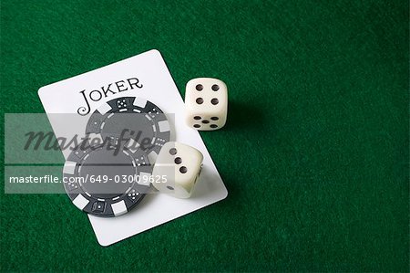 Joker card and gambling chips and dice