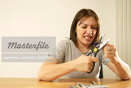 woman cutting credit cards