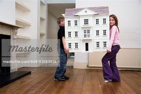 Two children carrying a dollhouse