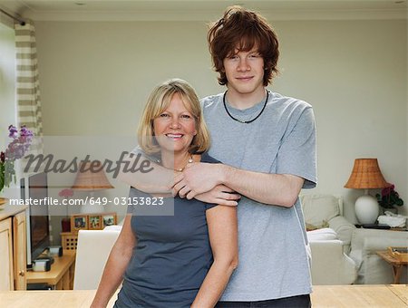 Son standing with arms around mother