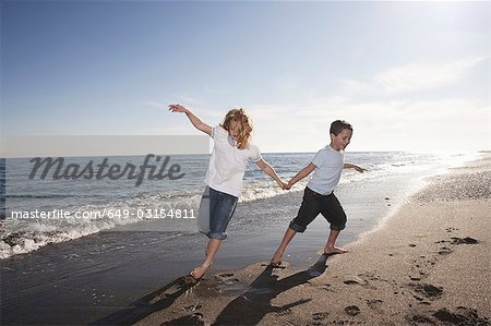 Boy and girl running on beach