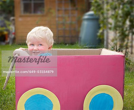 young boy standing in cardboard box