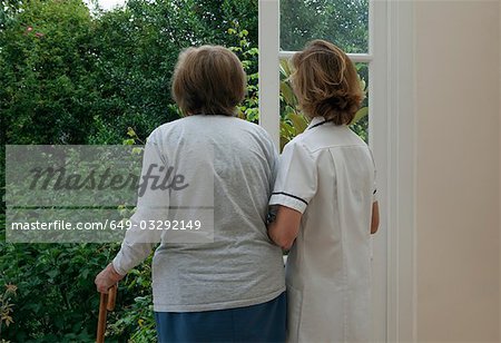 Nurse supporting elderly woman