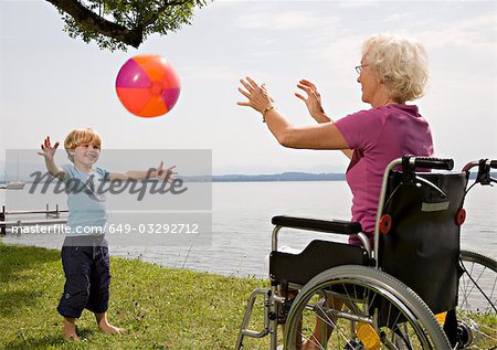 boy playing ball with senior woman