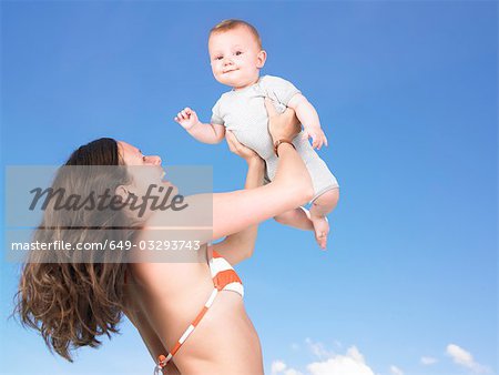 mother holding baby up in air
